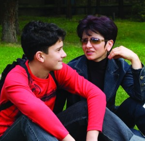 Mother and son mother and son sitting on the grass chatting