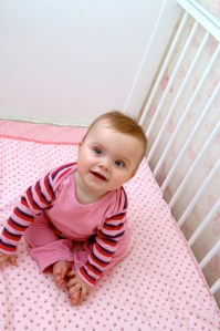 Baby sitting in crib