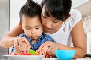 Mother and son cutting food