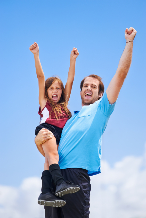soccer dad and daughter practising in the field