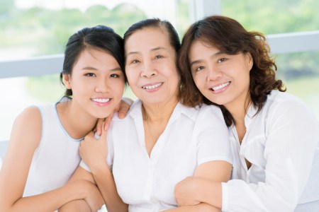 Three women, Senior woman, daughter and granddaughter sitting and embracing