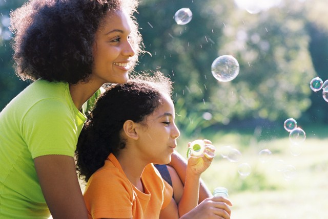 Content Mother and daughter blowing bubbles