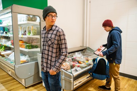 Two males in their late teens stealing in a grocery store.