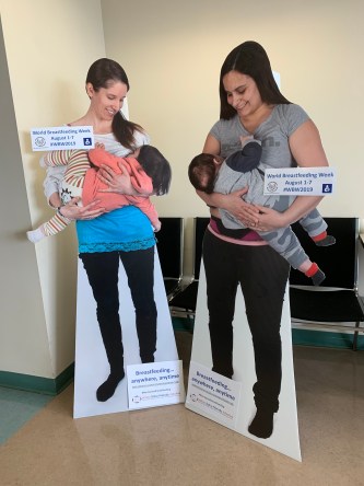 Two life size cut outs of moms breastfeeding their children in public
